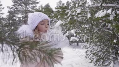 女孩用手掌吹雪，在森林冬<strong>天降</strong>雪时把雪吐上去，然后转身，竖起大拇指